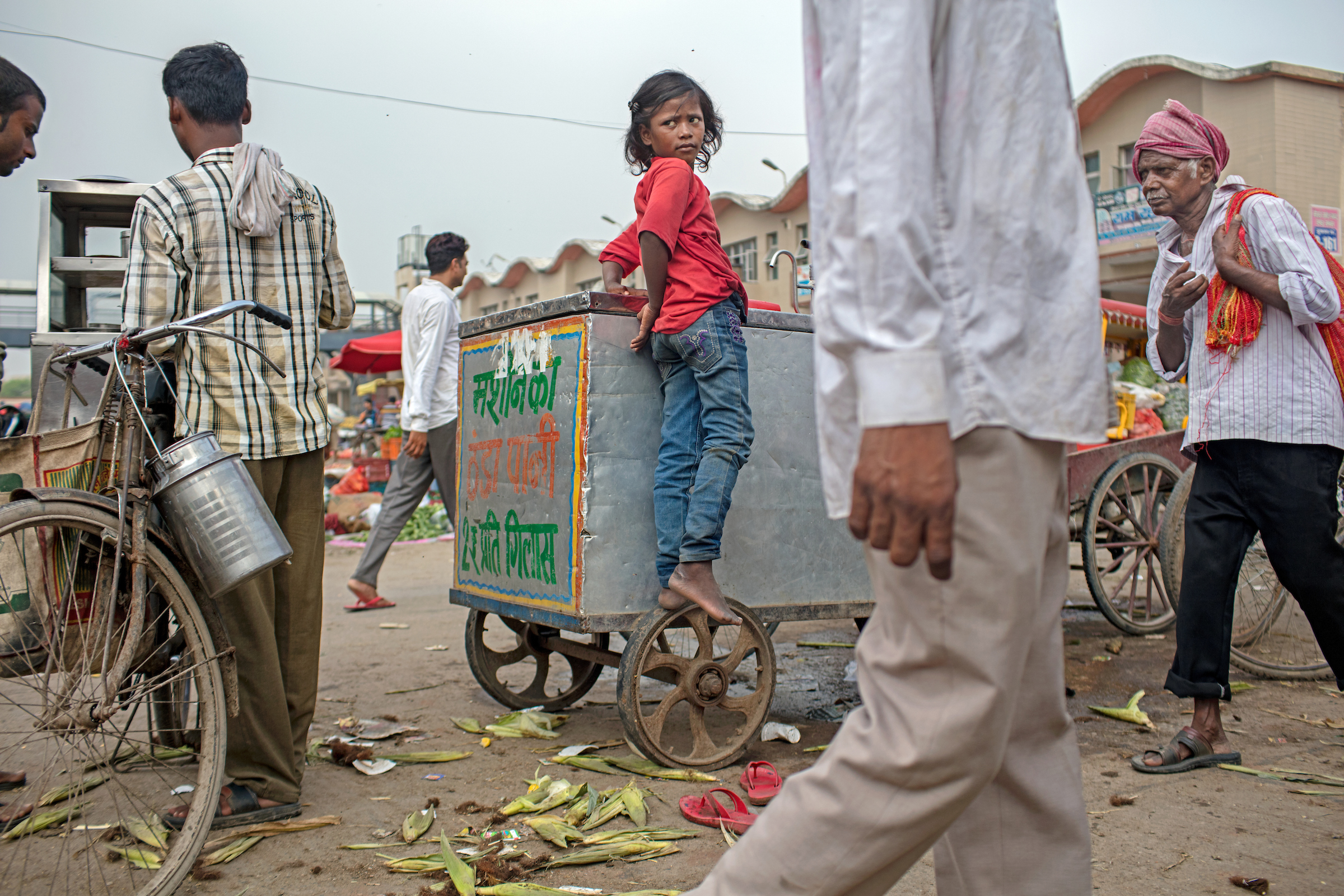 Aarti, 9, is vulnerable to sexual violence as she sells flowers alone on a rain-swept Delhi, India street.