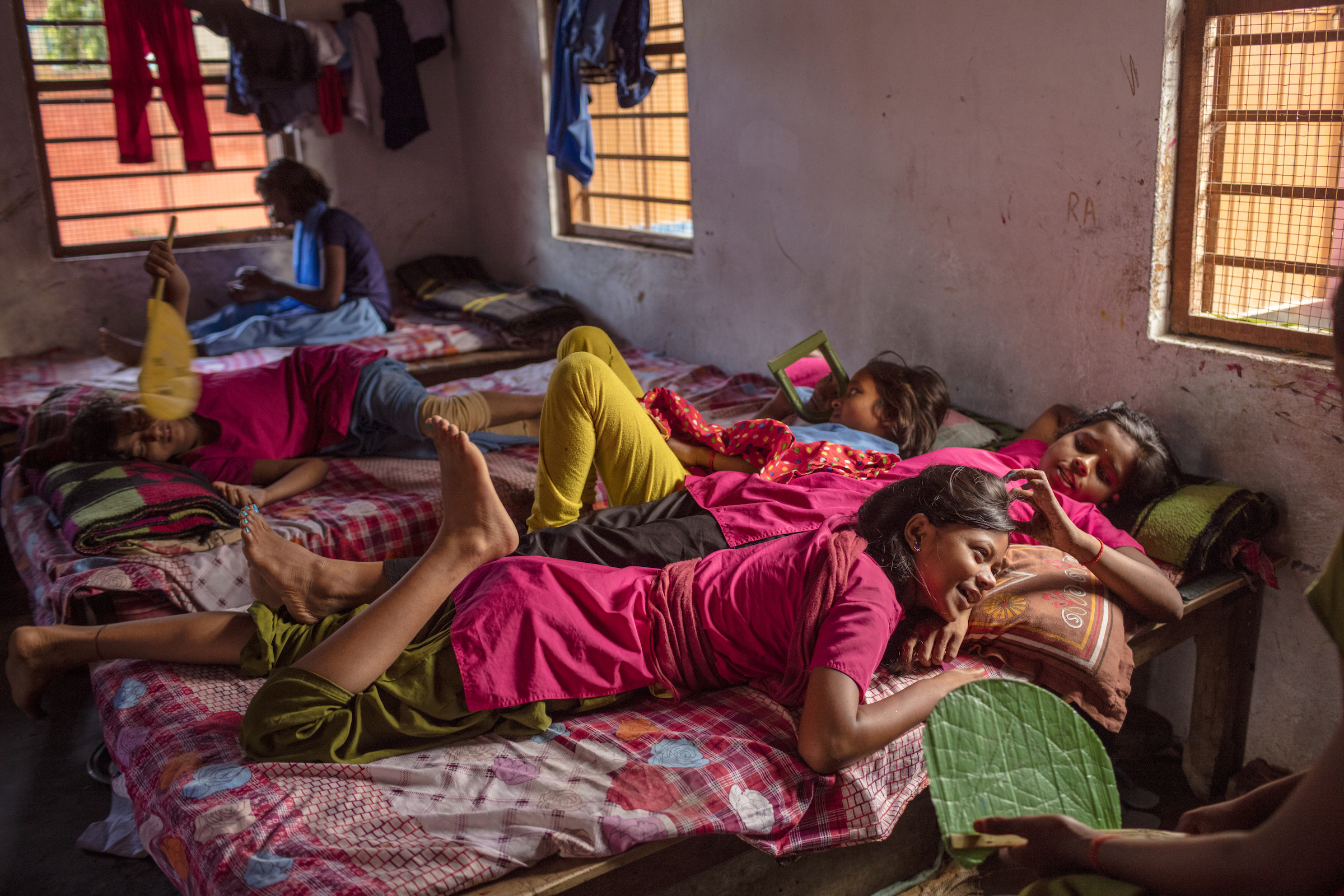 Rinki (foreground) and Arti relax beside each other in their room during a break between classes at their government-funded school, the Kasturba